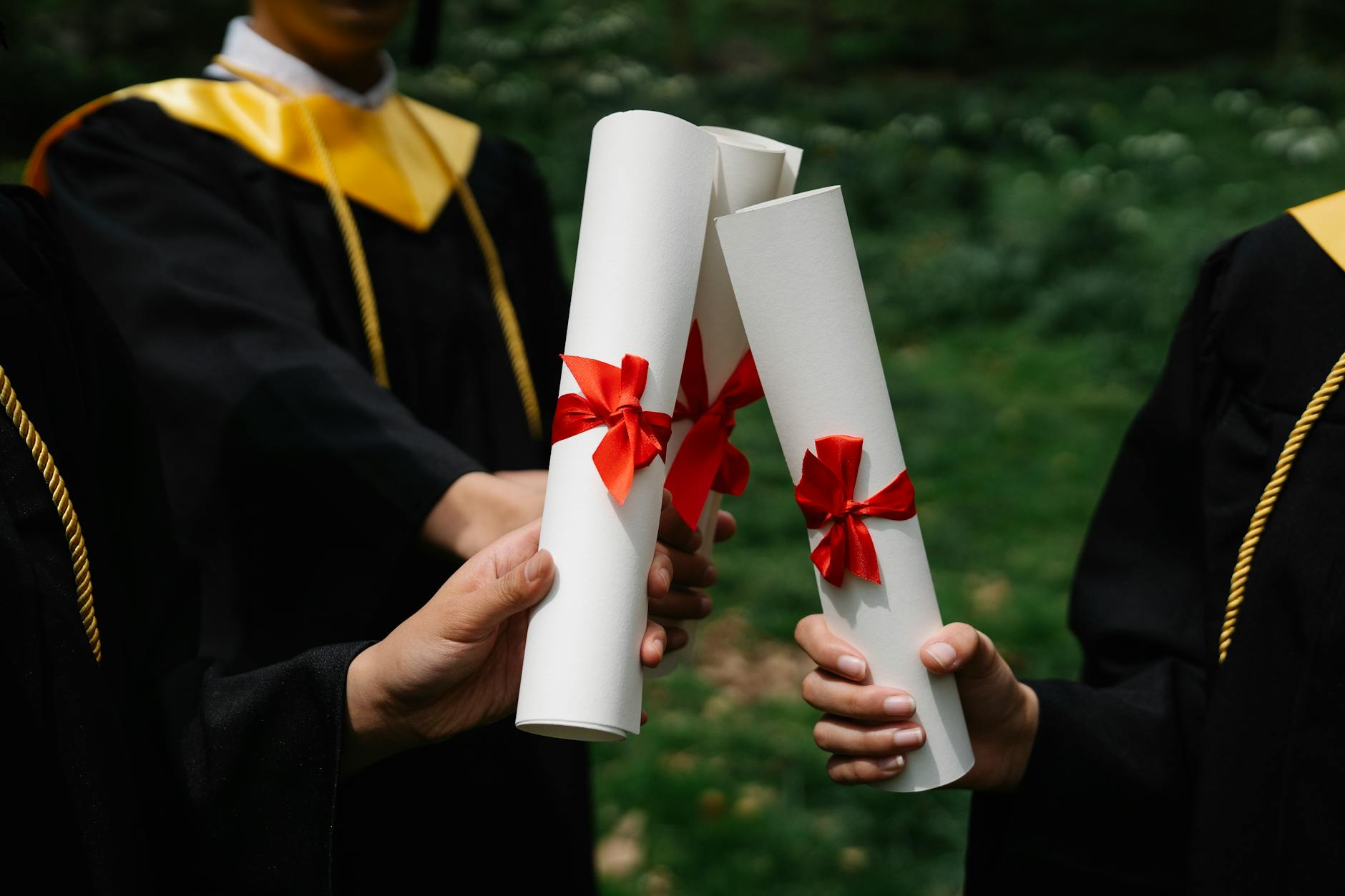 A medical graduate holding their diploma after successfully completing licensing requirements
